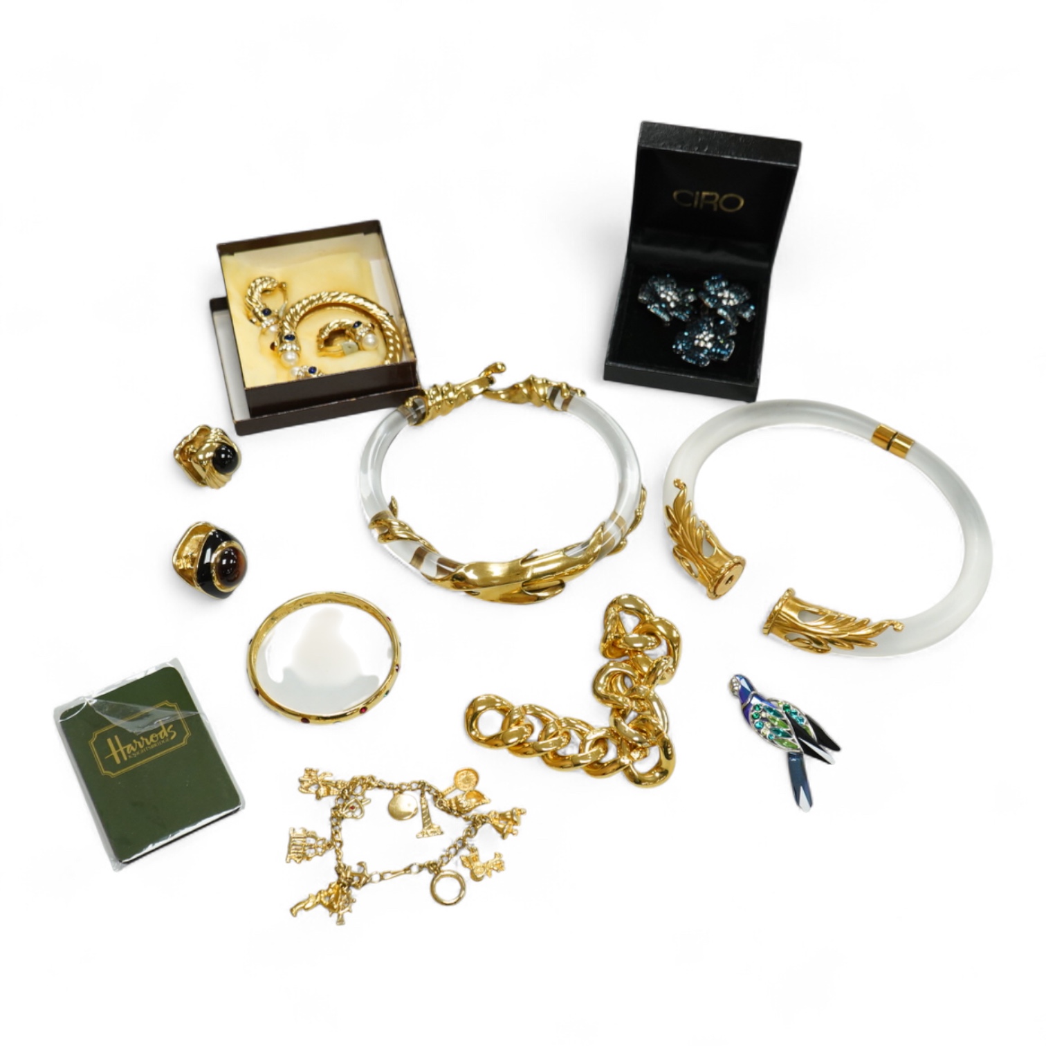 A small group of assorted costume jewellery including a 925 and paste set brooch and pair of ear clips and a gilt metal charm bracelet.
